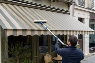 Nettoyage de store banne avec une raclette souple sur toile rayée