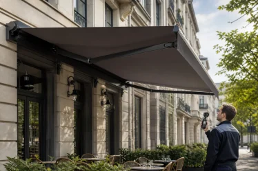 Store banne à bras articulés contrôlé avec un anémomètre devant une terrasse